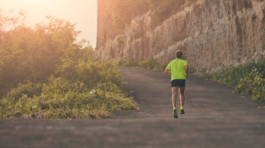 Banliyö dağ yolunda yokuş aşağı/yokuş yukarı adam jogging.