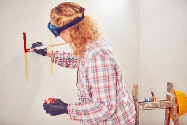 Working woman plastering / painting walls inside the house. — Stock Photo, Image