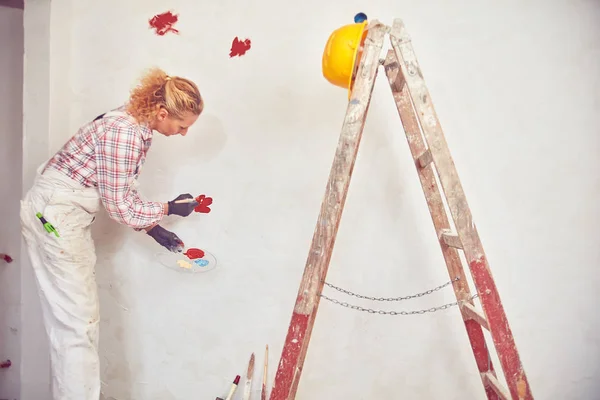 Mujer trabajadora enyesando / pintando paredes dentro de la casa . — Foto de Stock