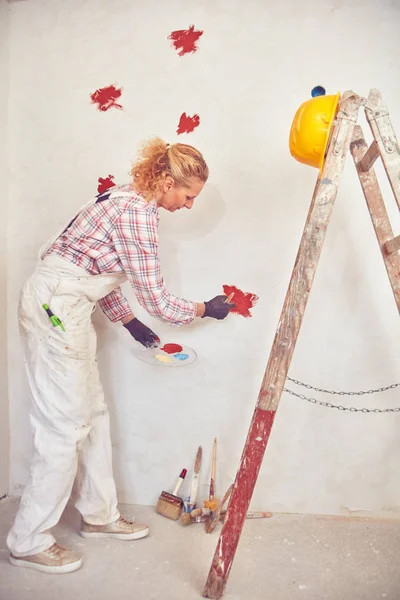 働く女性石膏/家の中の壁を塗装. — ストック写真