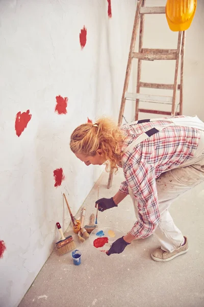 Mujer trabajadora enyesando / pintando paredes dentro de la casa . — Foto de Stock