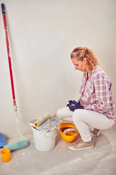 Werkende vrouw bepleistering/schilderen muren in het huis. — Stockfoto