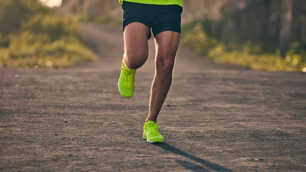 Hombre corriendo en una cuesta abajo / cuesta arriba en el camino de montaña suburbio . — Foto de Stock