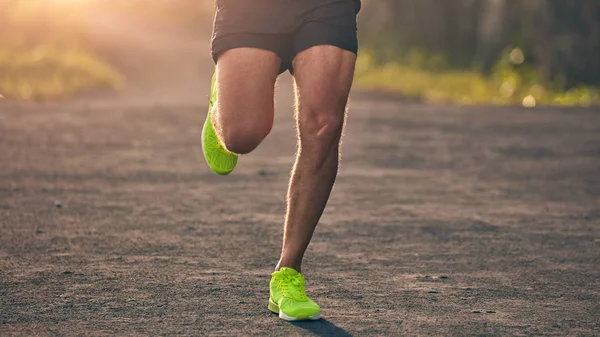 Hombre corriendo en una cuesta abajo / cuesta arriba en el camino de montaña suburbio . — Foto de Stock