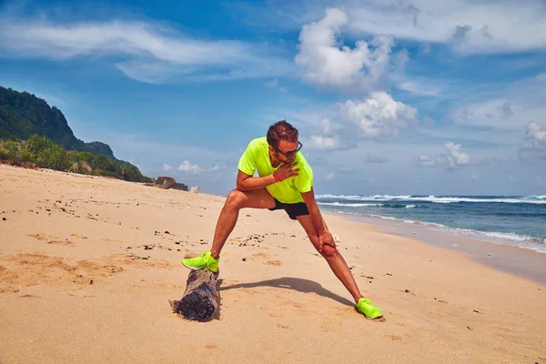 Sportivo che si estende su una spiaggia di sabbia tropicale . — Foto Stock