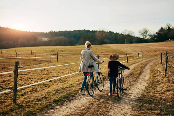 Mãe e filha com bicicletas no campo . — Fotografia de Stock