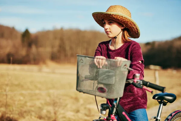 Nettes kleines zehnjähriges Mädchen fährt Fahrrad auf dem Land. — Stockfoto