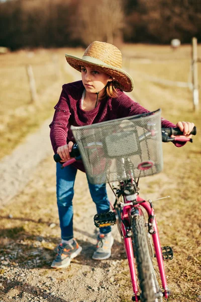 Nettes kleines zehnjähriges Mädchen fährt Fahrrad auf dem Land. — Stockfoto