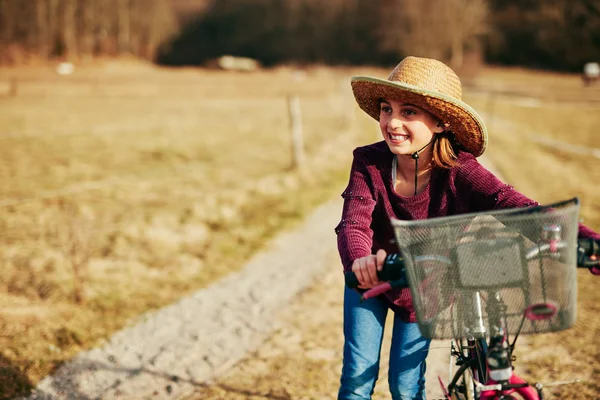 Nettes kleines zehnjähriges Mädchen fährt Fahrrad auf dem Land. — Stockfoto