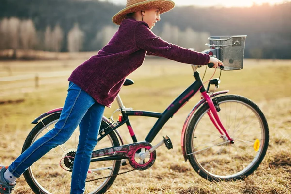 Nettes kleines zehnjähriges Mädchen fährt Fahrrad auf dem Land. — Stockfoto