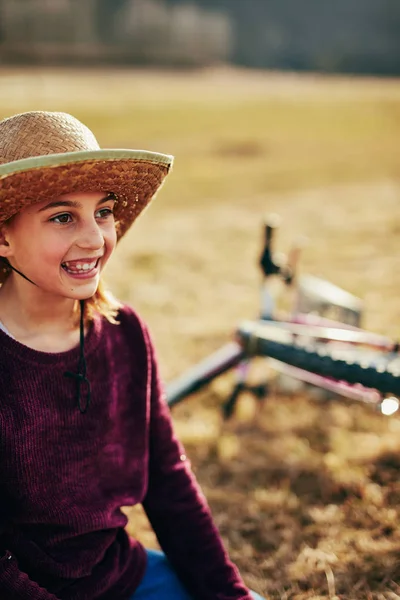 Linda niña de diez años montando bicicleta en el campo . — Foto de Stock