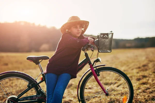 Nettes kleines zehnjähriges Mädchen fährt Fahrrad auf dem Land. — Stockfoto