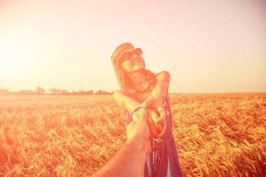 Genç çift zevk içinde bir buğday alan.