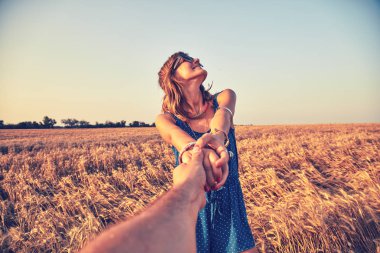 Genç çift zevk içinde bir buğday alan.