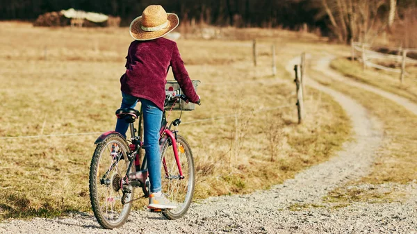 Nettes kleines zehnjähriges Mädchen fährt Fahrrad auf dem Land. — Stockfoto