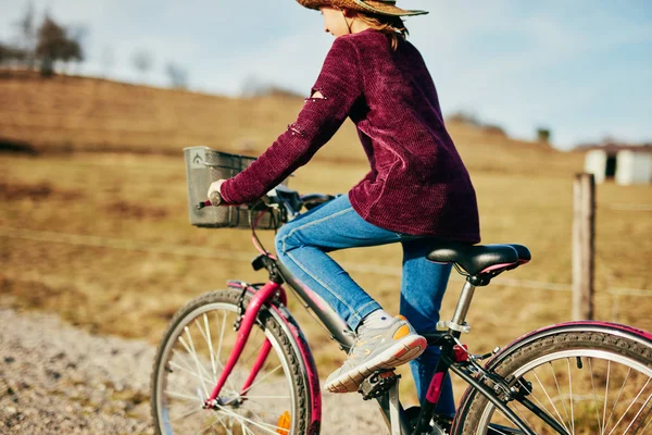 Nettes kleines zehnjähriges Mädchen fährt Fahrrad auf dem Land. — Stockfoto