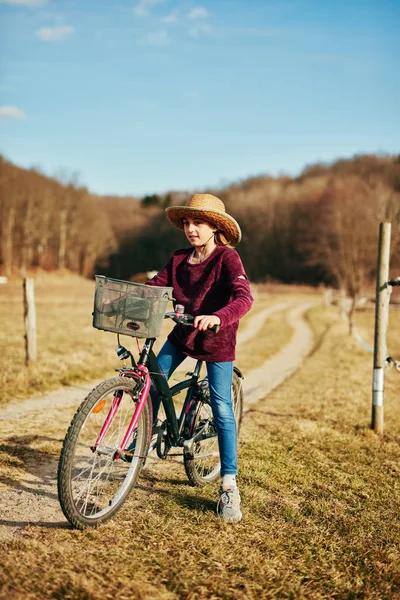 Nettes kleines zehnjähriges Mädchen fährt Fahrrad auf dem Land. — Stockfoto