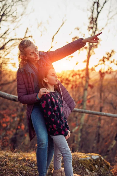 Mutter und Tochter betrachten ferne Landschaft bei Sonnenuntergang / Sonne — Stockfoto