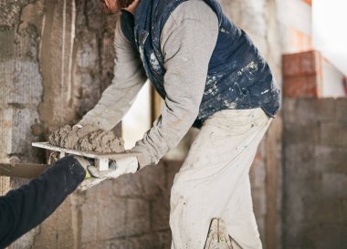 Gerçek inşaat işçisi yeni evin içinde bir duvar yapma.