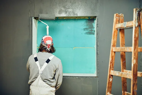 Painter painting walls with a extender roller indoors. — Stock Photo, Image