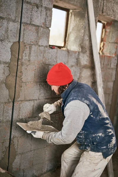 Pekerja konstruksi yang sebenarnya membuat dinding di dalam rumah baru . — Stok Foto