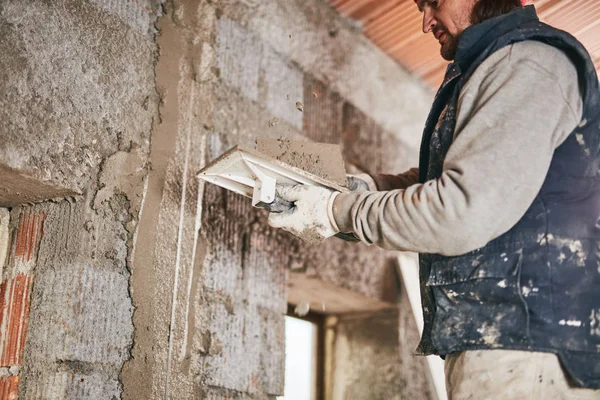 Vrai ouvrier de la construction faisant un mur à l'intérieur de la nouvelle maison . — Photo