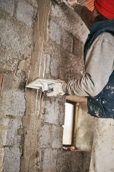 Vrai ouvrier de la construction faisant un mur à l'intérieur de la nouvelle maison . — Photo