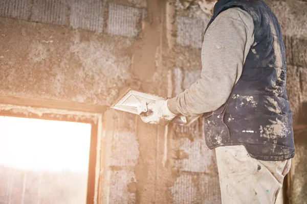 Vrai ouvrier de la construction faisant un mur à l'intérieur de la nouvelle maison . — Photo