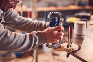 Erkek marangoz antika bir atölyede eski ahşap üzerinde çalışıyor..