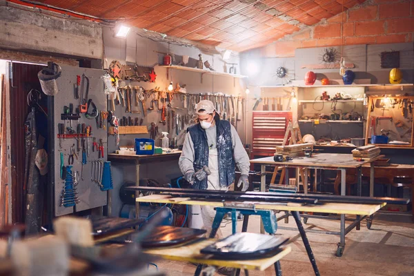 レトロなヴィンテージワークショップで古い木に取り組む男性大工. — ストック写真