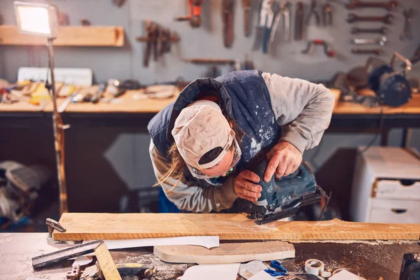Mannlig snekker som arbeider med gammelt tre på et retro-vintage verksted. – stockfoto
