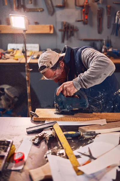 고풍 스러운 포도 작업장에서 오래 된 나무를 다루고 있는 남자 목수. — 스톡 사진
