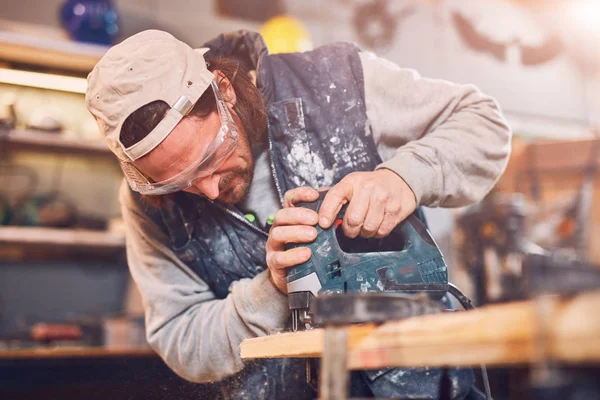 Male carpenter working on old wood in a retro vintage workshop. — Stock Photo, Image