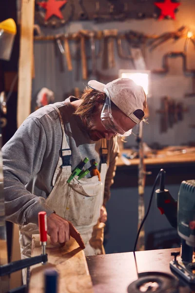 Male carpenter working on old wood in a retro vintage workshop. — Stock Photo, Image