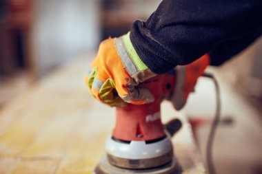 Erkek marangoz bir retro vintage orbital elektrikli zımpara kullanarak 