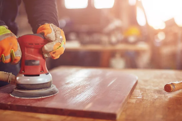 Male carpenter using orbital electric sander in a retro vintage — Stock Photo, Image