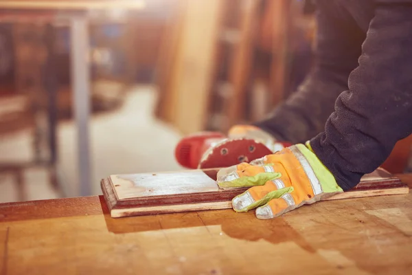 Male carpenter using orbital electric sander in a retro vintage — Stock Photo, Image