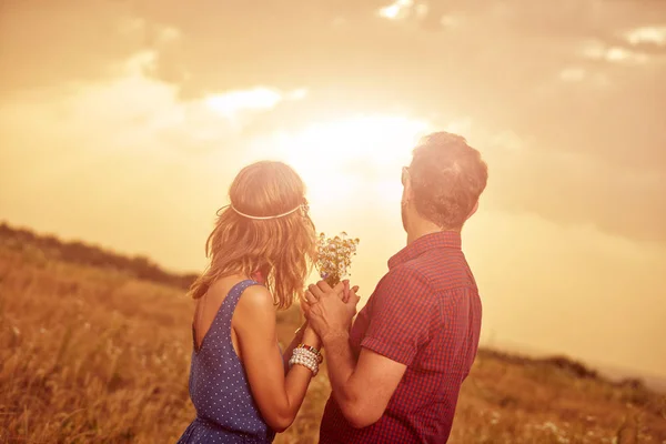 Pareja en la puesta del sol / salida del sol en un campo de trigo . —  Fotos de Stock