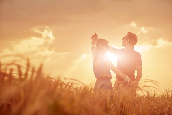 Couple au coucher / lever du soleil dans un champ de blé . — Photo