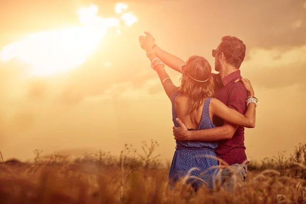 Couple in sunset / sunrise time in a wheat field. — Stock Photo, Image