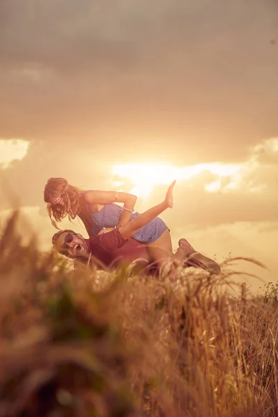 Paar bei Sonnenuntergang / Sonnenaufgang in einem Weizenfeld. — Stockfoto