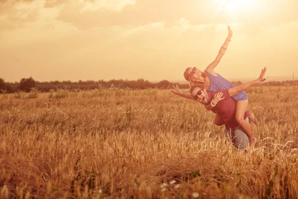 Pareja en la puesta del sol / salida del sol en un campo de trigo . —  Fotos de Stock