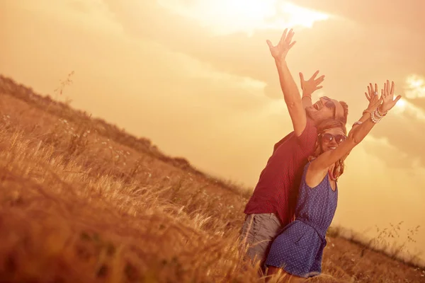 Couple in sunset / sunrise time in a wheat field. — Stock Photo, Image