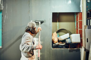 Kapalı bir uzatıcı silindir ile ressam boyama duvarları.