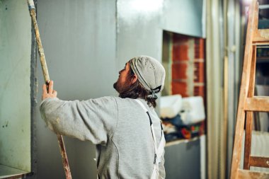 Kapalı bir uzatıcı silindir ile ressam boyama duvarları.