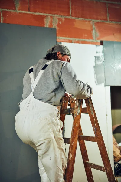 Pintor pintando paredes con un rodillo extensor en interiores . — Foto de Stock