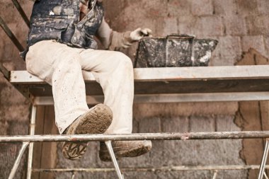 Gerçek inşaat işçisi yeni evin içinde bir duvar yapma.