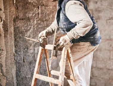 Gerçek inşaat işçisi yeni evin içinde bir duvar yapma.