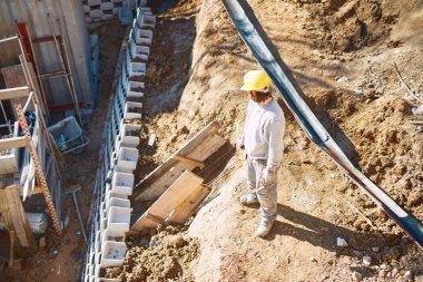 Ağır bir sitede inşaat işçisi sıkı çalışma yapıyor.