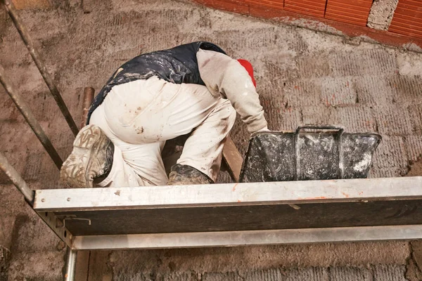 Vrai ouvrier de la construction faisant un mur à l'intérieur de la nouvelle maison . — Photo